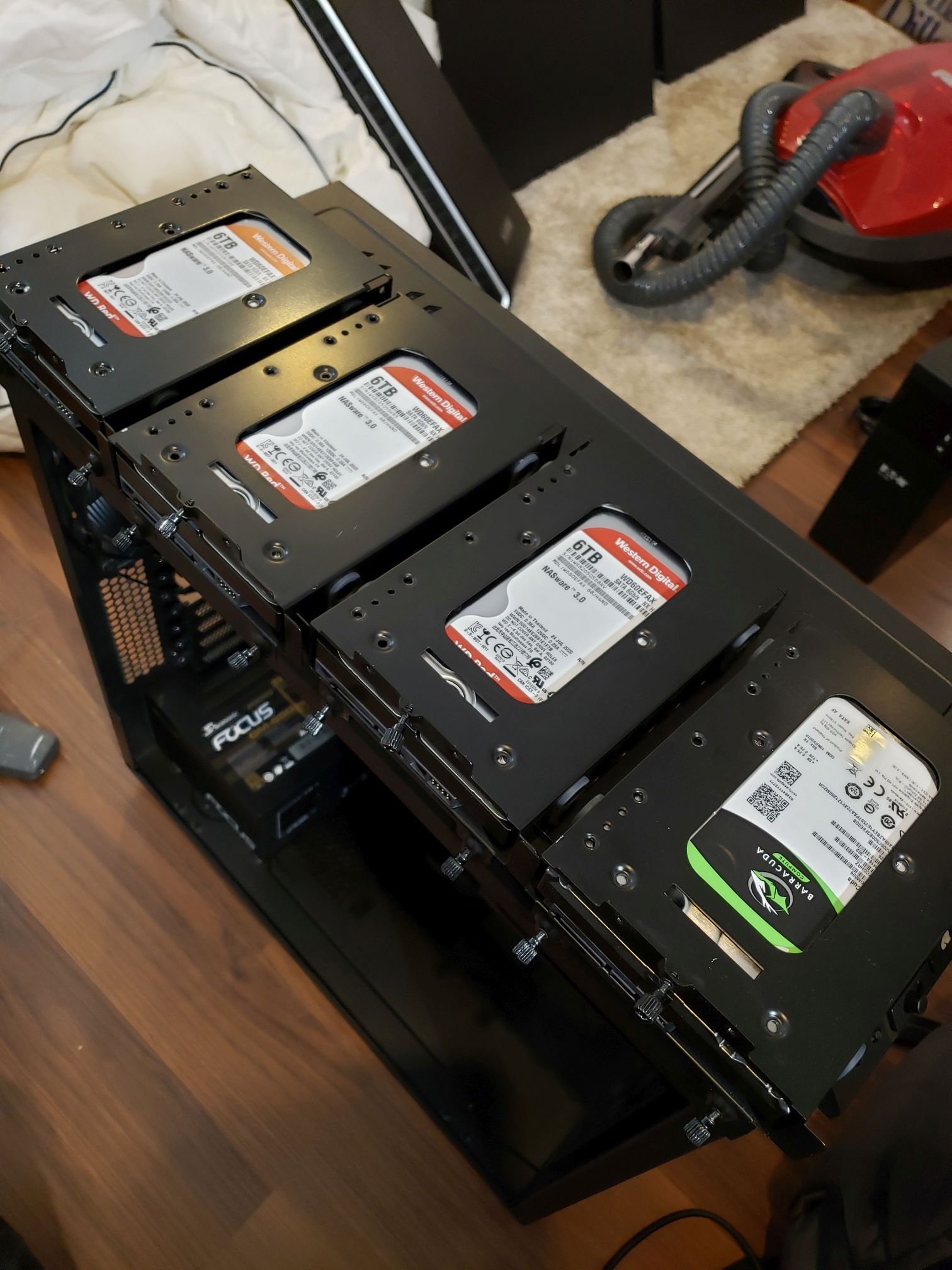 4 Hard drives in caddies sitting on top of a computer case